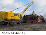 Железнодорожный кран КЖ-462 "Первомаец" загружает углем паровоз Л-3958 октябрьским утром. Станция Сортавала, Карелия (2022 год). Редакционное фото, фотограф Виктор Карасев / Фотобанк Лори