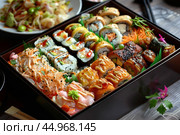 Bento box full of freshly made sushi being served on restaurant table. Стоковое AI-изображение, AI-художник Иван Рябоконь / Фотобанк Лори