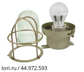 Осветительная лампа с защитным металлическим кожухом на белом фоне. A lighting lamp with a protective metal casing isolated over white background. Стоковое фото, фотограф Татьяна Д / Фотобанк Лори