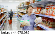 Woman in supermarket buys daily groceries, pasta Chinese noodles. Стоковое видео, видеограф Яков Филимонов / Фотобанк Лори