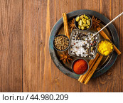 Oriental spice set - coriander, red pepper, turmeric, cinnamon, star anise, various seasonings in metall cups, on brown dark wooden table, top view, macro, empty space. Стоковое фото, фотограф Natalia Gdovskaia / Фотобанк Лори