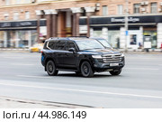Toyota Land Cruiser 300 rides on the city highway. Black premium SUV on the city street in motion. Редакционное фото, фотограф Константин Григорьев / Фотобанк Лори