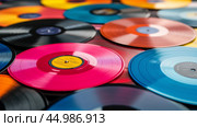Colorful collection of vinyl records displayed on a flat surface in natural lighting. Стоковое AI-изображение, AI-художник Юлия Гапеенко / Фотобанк Лори