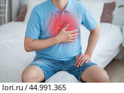 Heart attack, acute heartache, man suffering from chest pain at home, myocardial infarction. Стоковое фото, фотограф Станислав Тарко / Фотобанк Лори