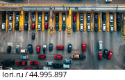 Traffic congestion at a busy toll plaza during the late afternoon rush hour with a mix of vehicles lining up for payment. Стоковое AI-изображение, AI-художник Сергей Толмачёв / Фотобанк Лори