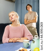 Upset woman sitting at home after disagreements with teenage son. Стоковое фото, фотограф Яков Филимонов / Фотобанк Лори
