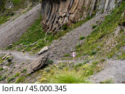 Mountain trekking. Hiker with trekking sticks climbs steep on mountain trail. Mountain landscape. Tourism, sport life style concept. Стоковое фото, фотограф Павел Муравьев / Фотобанк Лори