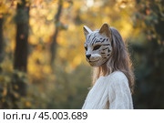 Quadrobics, quads. Teenage girl wearing a tiger cat mask. Quadrober youth subculture concept. Blog, social media, or news article. Child in an animal furry mask walking outdoors. Quadrobeast Lifestyle. Стоковое AI-изображение, AI-художник Марина Демидюк / Фотобанк Лори