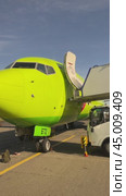 IRKUTSK, RUSSIA - September 13, 2024: Vertical video of preparation for flight of modern green aircraft of S7 Airlines, loading of luggage onto airplane and moving of  mobile boarding ramp for passenger. Редакционное видео, видеограф Виктория Катьянова / Фотобанк Лори