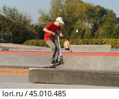 Moscow, Russia - September 5, 2019: Young skateboarder performs a trick on a shabby city sports ground. Boy jumping over an obstacles. Extreme sports is very popular among youth. Side view. Редакционное фото, фотограф YuryKara / Фотобанк Лори