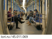 Moscow, Russia - October 14, 2019: Photography of people in the carriage of Moscow subway train. Somebody reading book, somebody is in smartphone. The interior of carriage. Urban culture. Редакционное фото, фотограф YuryKara / Фотобанк Лори