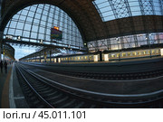 Moscow, Russia - October 13, 2019: Photography of Kiyevsky railway station in autumn sunset. Electric train is leaving now. Fish-Eye lens. Редакционное фото, фотограф YuryKara / Фотобанк Лори