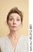 Woman with surprised exaggerated expression on neutral background. Стоковое AI-изображение, AI-художник Анастасия Золотницкая / Фотобанк Лори