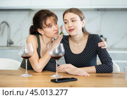 Sad woman sits silently in kitchen, friend sympathize and comfort her. Стоковое фото, фотограф Яков Филимонов / Фотобанк Лори