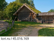 View of an ancient log outbuilding on the territory of the Pushkin village in Bugrovo of the Pushkin Museum-Reserve on a sunny summer day, Pushkinskiye Gory, Pskov region, Russia. Редакционное фото, фотограф Ula Ulachka / Фотобанк Лори