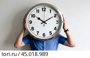 Person holding large wall clock in front. Стоковое AI-изображение, AI-художник Андрей Бакусов / Фотобанк Лори