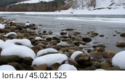 A small river flows over the rocks, creating a wintery Siberian landscape. Небольшая речка бежит по камням, зимний сибирский пейзаж. Стоковое видео, видеограф Валерий Тесаков / Фотобанк Лори