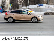 Car Volvo V40 in fast motion with blurred urban background. Beige color 5-door hatchback is driving on high speed, side view. Редакционное фото, фотограф Константин Григорьев / Фотобанк Лори
