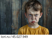 Young boy making angry face expression. Стоковое AI-изображение, AI-художник Иван Рябоконь / Фотобанк Лори
