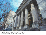 Imposing courthouse building with columns standing tall in winter. Стоковое AI-изображение, AI-художник Иван Рябоконь / Фотобанк Лори