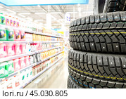 Winter vehicle tires stacked up for sale in the chain hypermarket. Стоковое фото, фотограф FotograFF / Фотобанк Лори