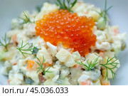 Traditional russian olivier salad garnished with red caviar and fresh dill. Стоковое фото, фотограф Данил Руденко / Фотобанк Лори