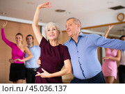 Cheerful elderly couple practicing ballroom dances in ballroom. Стоковое фото, фотограф Яков Филимонов / Фотобанк Лори