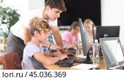 Guy teacher teaches boy student to work with computer. Стоковое видео, видеограф Яков Филимонов / Фотобанк Лори