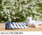 Medicine pills, handkerchief on table on green nature background. Стоковое фото, фотограф Natalia Gdovskaia / Фотобанк Лори