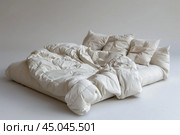 Unmade bed with white linen is waiting in empty room. Стоковое AI-изображение, AI-художник Иван Рябоконь / Фотобанк Лори