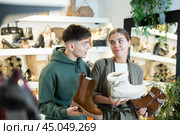 Guy male friend strongly recommends his young woman colleague to pay attention to model of boots. Стоковое фото, фотограф Яков Филимонов / Фотобанк Лори