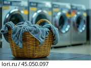 Laundry day, basket with clothes at laundromat. Стоковое AI-изображение, AI-художник Иван Рябоконь / Фотобанк Лори