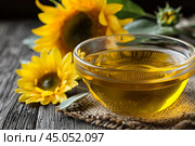 Glass bowl overflowing with sunflower oil and sunflowers. Стоковое AI-изображение, AI-художник Иван Рябоконь / Фотобанк Лори