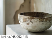 Old ceramic bowl with craquelure standing on white surface. Стоковое AI-изображение, AI-художник Иван Рябоконь / Фотобанк Лори