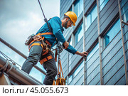 A male construction worker in protective gear, safety belts and with safety belt hooks for working at high altitude. Construction, repair, cleaning, installation. Стоковое AI-изображение, AI-художник Photojuli / Фотобанк Лори