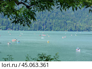 Прогулочные лодки и водные велосипеды на озере Рица в Абхазии летом (2023 год). Редакционное фото, фотограф Александр Замараев / Фотобанк Лори