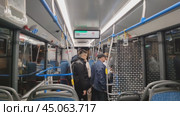 Вид из салона автобуса. Автобус с пассажирами едет по ночному городу. Люди выходят из дверей на автобусной остановке. Современный городской общественный транспорт. Россия, Москва, 8 октября 2024 года. Редакционное видео, видеограф Ирина / Фотобанк Лори