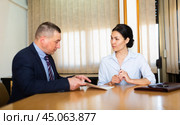 Businessman inviting female business partner to sign papers. Стоковое фото, фотограф Яков Филимонов / Фотобанк Лори