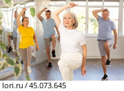 Woman participating in Zumba class for seniors in fitness studio. Стоковое фото, фотограф Яков Филимонов / Фотобанк Лори