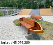 Деревянная скамейка в виде лодки. Парк культуры и отдыха им. А.С. Пушкина, станица Северская, Краснодарский край (2023 год). Редакционное фото, фотограф Мария Кылосова / Фотобанк Лори