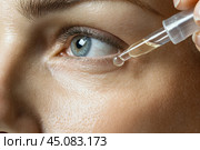 Young woman applying serum on her face. Caucasian 20s girl holding dropper skin care product. Female applies essential oil with oily pipette. Advertising facial care cosmetics. Health, youth. Serums. Стоковое AI-изображение, AI-художник Марина Демидюк / Фотобанк Лори
