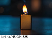 Горящая зажигалка на столе в темной комнате. Copy ad text space. Стоковое AI-изображение, AI-художник Щеголева Ольга / Фотобанк Лори