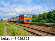 Moscow region, Russia, July 2018: Passenger electric train of the Russian Railways ED4M moves against a background of green forest (editorial) Стоковое фото, фотограф Михаил Строгалев / Фотобанк Лори