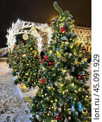 SAINT PETERSBURG, RUSSIA -December 25, 2023: Christmas and New Year holidays in Petersburg. View of festively decorated St. Isaac's Square with Christmas trees near Mariinskiy Palace at X-mas evening. Редакционное фото, фотограф Виктория Катьянова / Фотобанк Лори