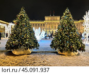 SAINT PETERSBURG, RUSSIA -December 25, 2023: Christmas and New Year holidays in Petersburg. View of festively decorated St. Isaac's Square with Christmas trees near Mariinskiy Palace at X-mas evening. Редакционное фото, фотограф Виктория Катьянова / Фотобанк Лори