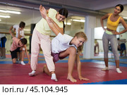 Girls and boys try to make painful grip on the attacker arm during training in self-defense lesson. Стоковое фото, фотограф Яков Филимонов / Фотобанк Лори