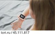 A little girl wears a smartwatch on her wrist and controls the functions by tapping on the screen. Стоковое видео, видеограф Енваев Андрей / Фотобанк Лори