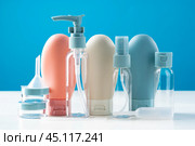 Variety of travel-sized containers displayed against a bright blue background. Стоковое фото, фотограф Сергей Толмачёв / Фотобанк Лори