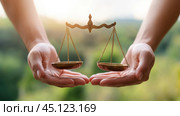 Balanced scales held gently in hands symbolize justice and fairness in a serene setting, AI. Стоковое AI-изображение, AI-художник Сергей Старуш / Фотобанк Лори