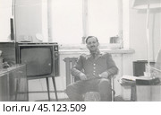 Мужчина в военной форме сидит в кресле рядом с телевизором. 1970-е годы. Стоковое фото, фотограф Retro / Фотобанк Лори